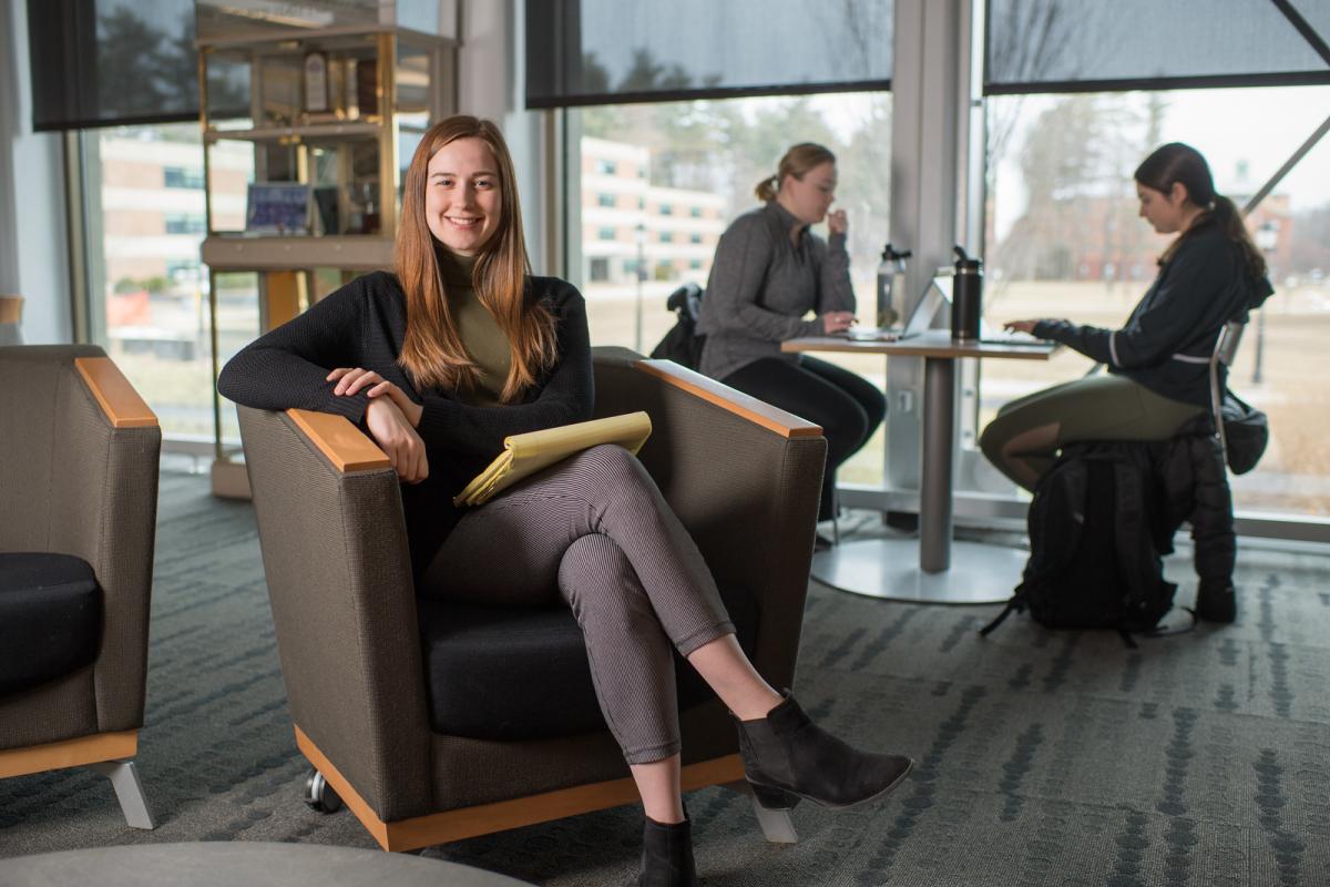 Counseling student in the library holding note pad