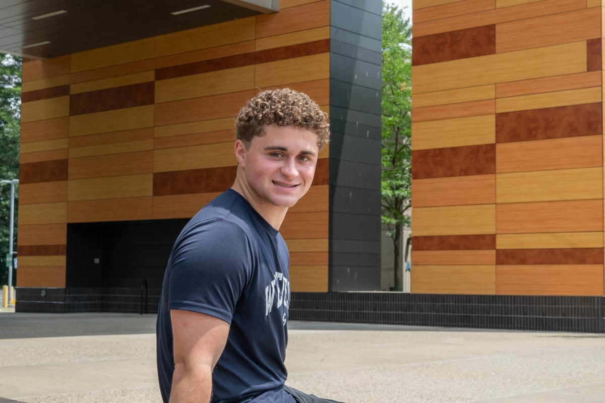 Student outside University Hall smiling.