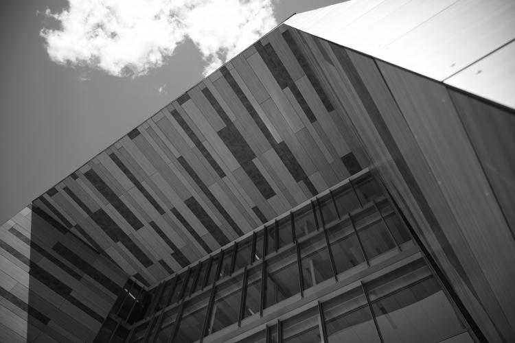 image looking up at the University hall archway with blue sky and clouds in the background