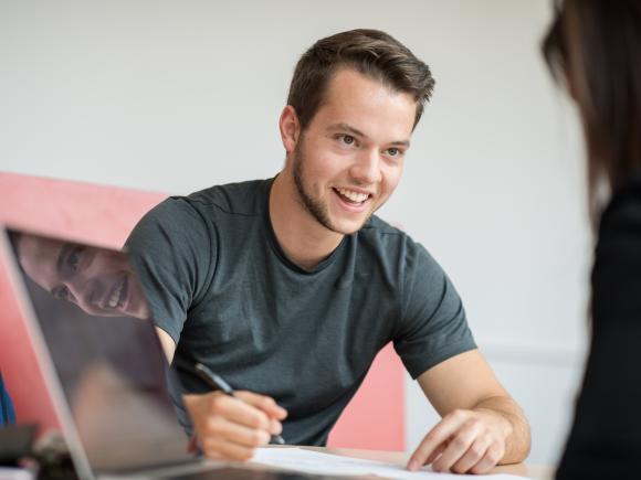 Westfield State student Austin Buckner smiles across a table at his friend