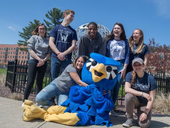 nestor surrounded by students in front of the globe on the campus green