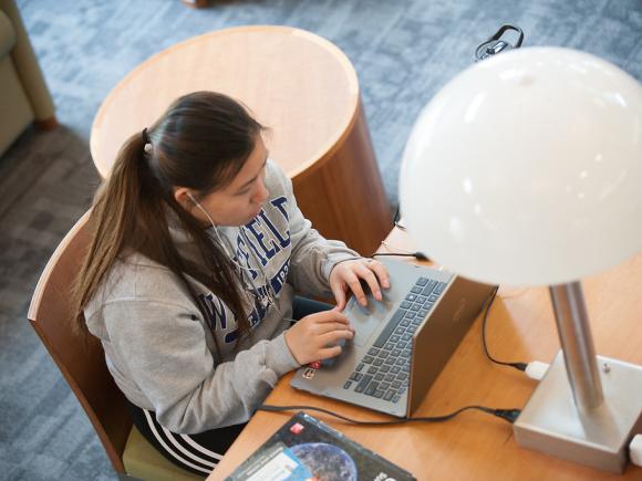 Female student working her laptop in the Ely Library