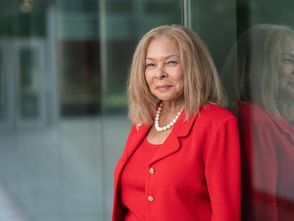 Westfield State President Linda Thompson stands next to a glass wall