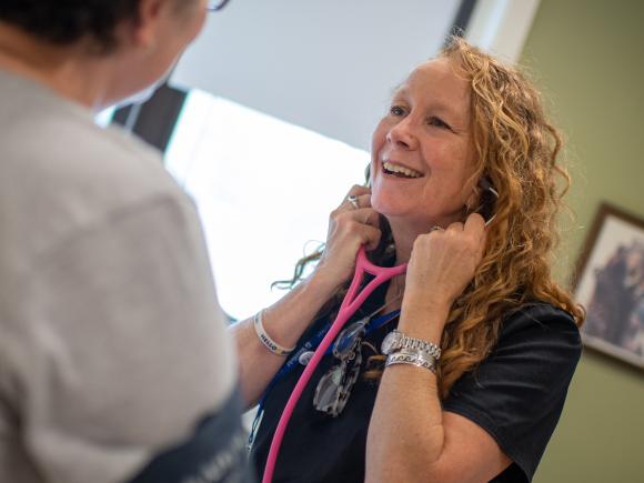 Health Services Director Kelly Palm with stethoscope and patient