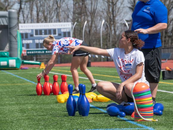 Student at Movement Science PE Day on a field with bowling pins.