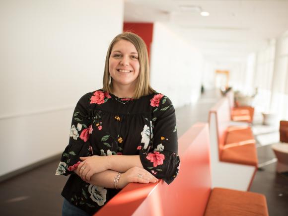 Counseling graduate student smiling in Nettie Stevens Science Center lobby wearing floral shirt.