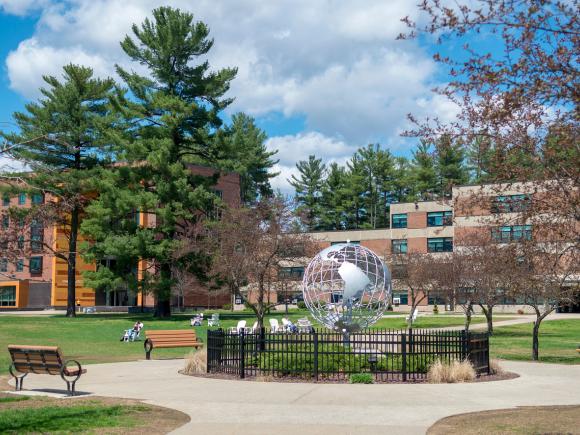 Campus globe in the summer with blue skies behind it.