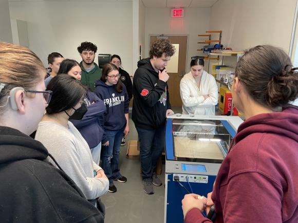 Graphic design students in RIDE Center working with a laser printer.