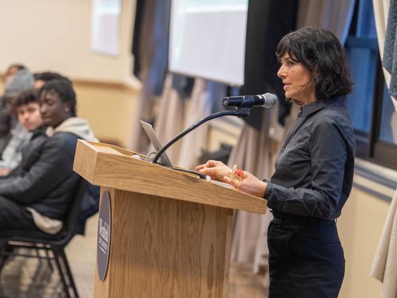 A Westfield State University professor presents to their students while standing at a podium.