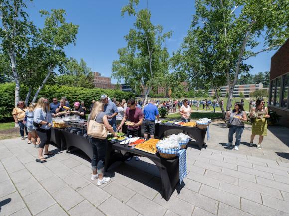 New Student Orientation. Families eat lunch outside next to the Dining Hall in rows of buffet tables.