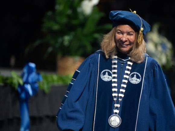 President Linda Thompson at the Undergraduate Commencement Ceremony. She is dressed in blue robes and a blue cap.