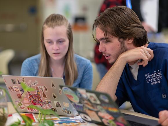 Two students working together in front of a lap top in the CARE Center.