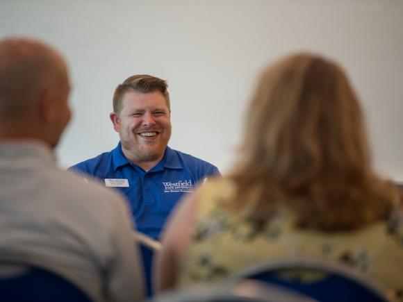 Director of Student Activities, Involvement, and Leadership, Matt Dellea. He is in a blue polo shirt and speaking to parents for New Student Orientation Day.