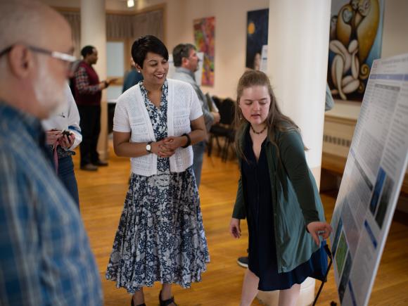 Regional planning student giving a presentation with a faculty member smiling.