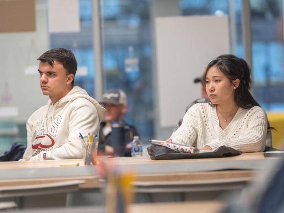 Two students listen at an entrepreneurial seminar.