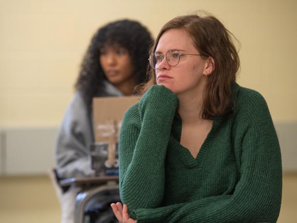 Two students sitting in a classroom, listening attentively to a lecture.