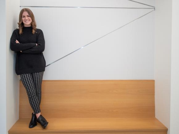 Smiling math student standing on a bench.