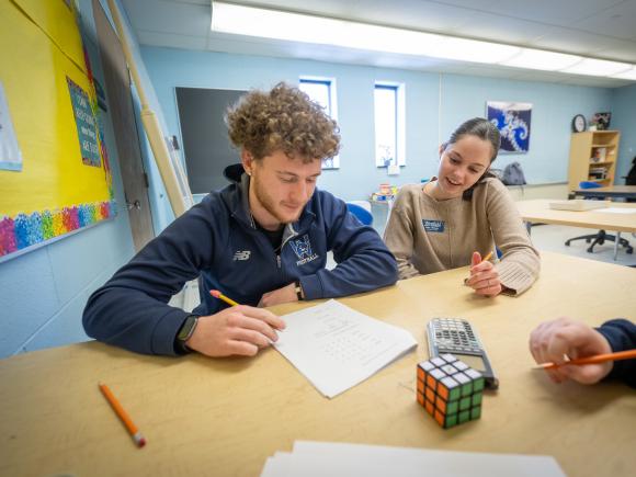 Math tutor assisting a student during a one-on-one study session.