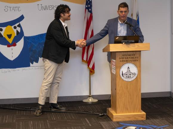 Student shaking hands with Senator Velis during a visit to the Student Government Association.
