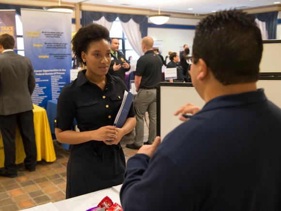 Student speaking with an employer at the job and internship fair.