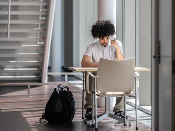 A student sits studying in the lobby of the Stevens Science Center.