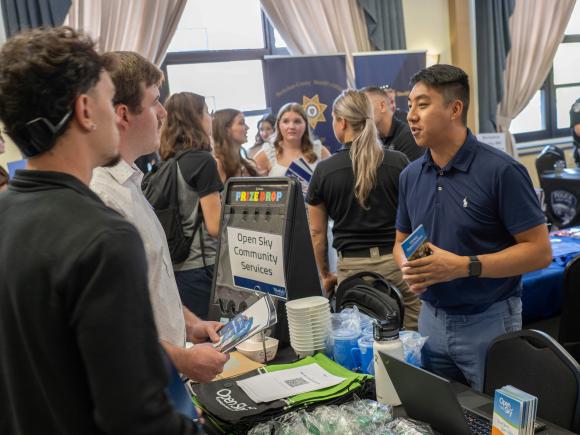 People talk at a table career fair