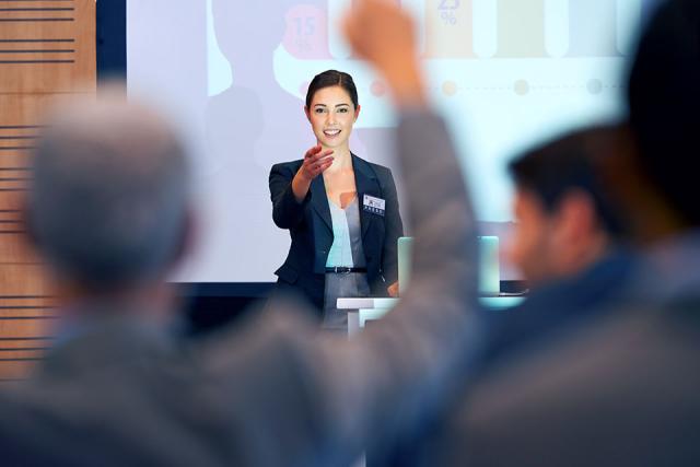 female professional presenter with screen behind