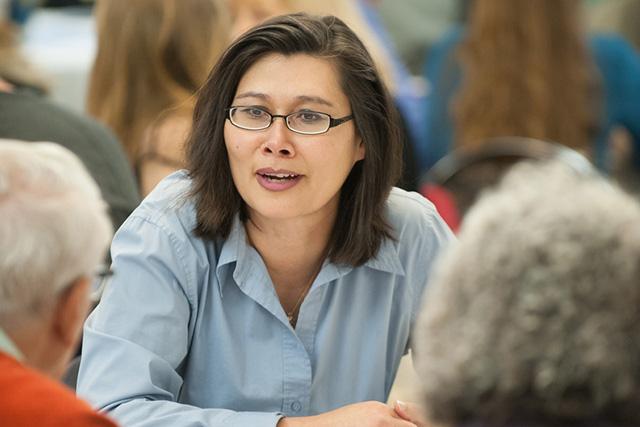 Faculty member speaking with two other people in a classroom setting.