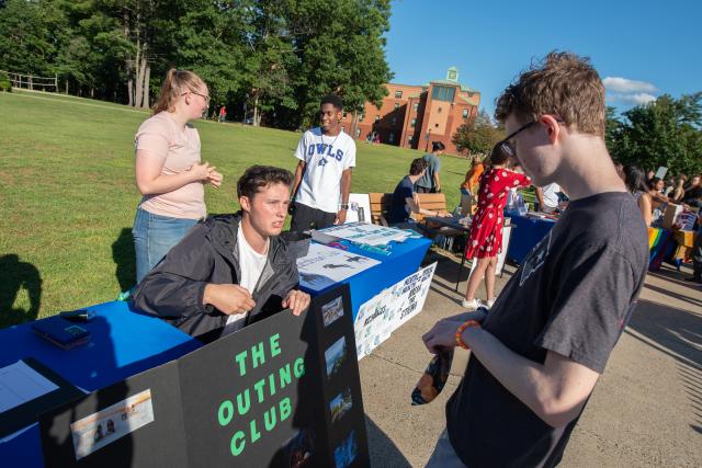 Outing Club with student looking at table items