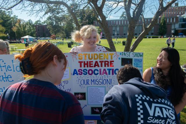 Student Theatre Association Club Students Smiling with Poster