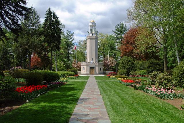 Tower at Stanley Park with red flowers and stone path.