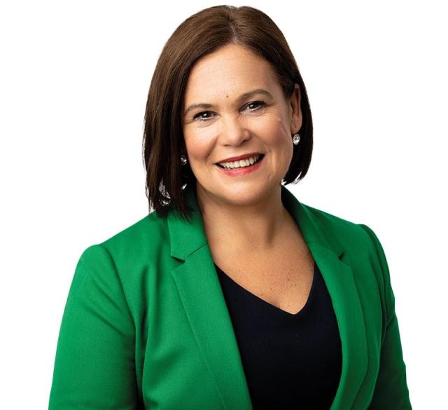 Mary Louise McDonald, President of Ireland's Sinn Féin political party wearing green blazer with short brown chin length hair.