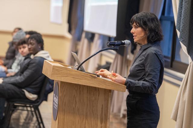 A Westfield State University professor presents to their students while standing at a podium.