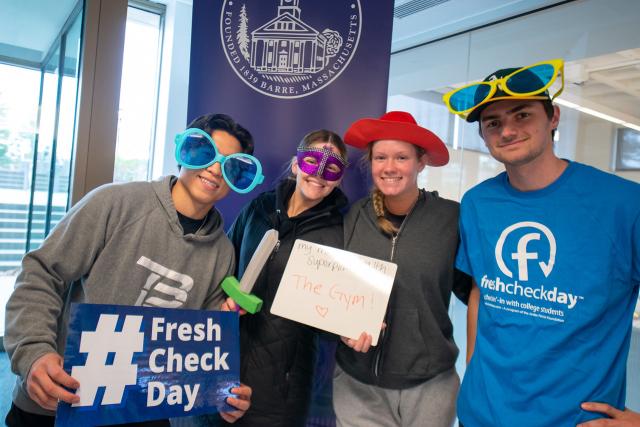 Students at Fresh Check Day wearing fun glasses and hats smiling.