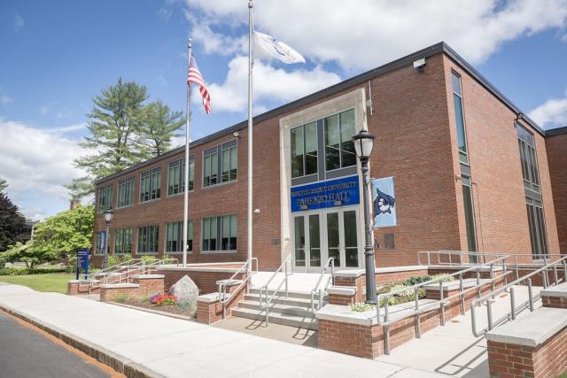 Exterior of Parenzo Hall with owl flag on light post.