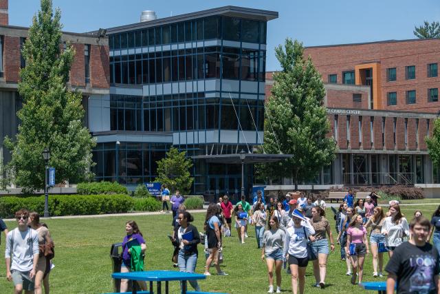 New Student Orientation with students walking on campus green.