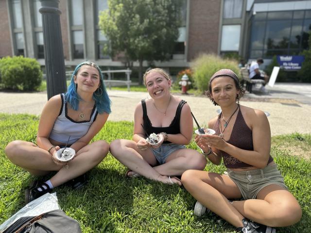 New Student Orientation with three students smiling eating ice cream.