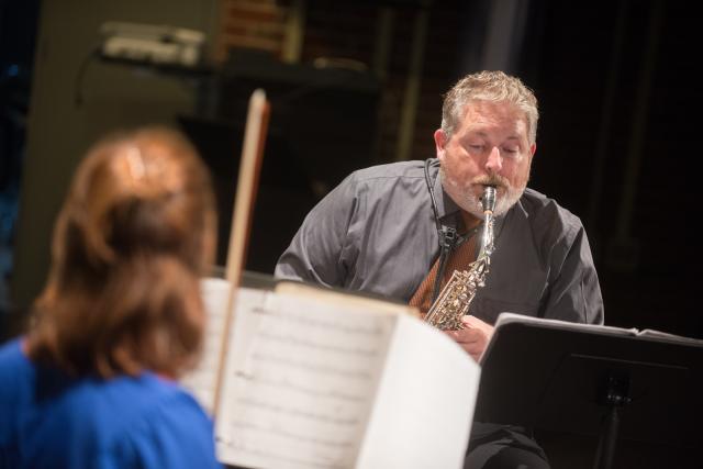 Faculty member performing on stage during A Chance Music Recital.