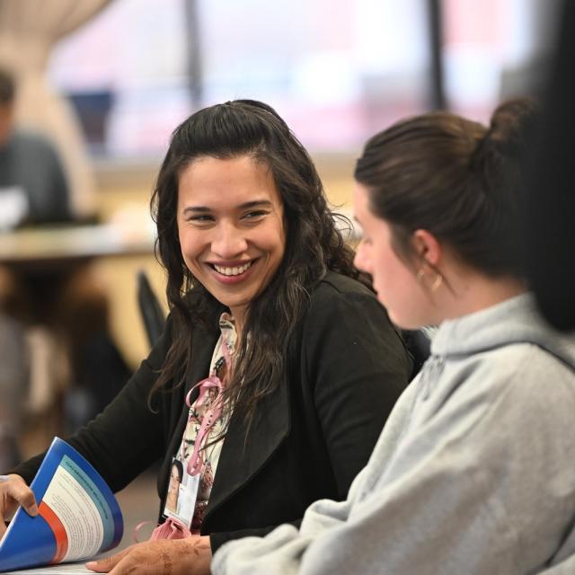 Two students collaborating over textbooks and notes.