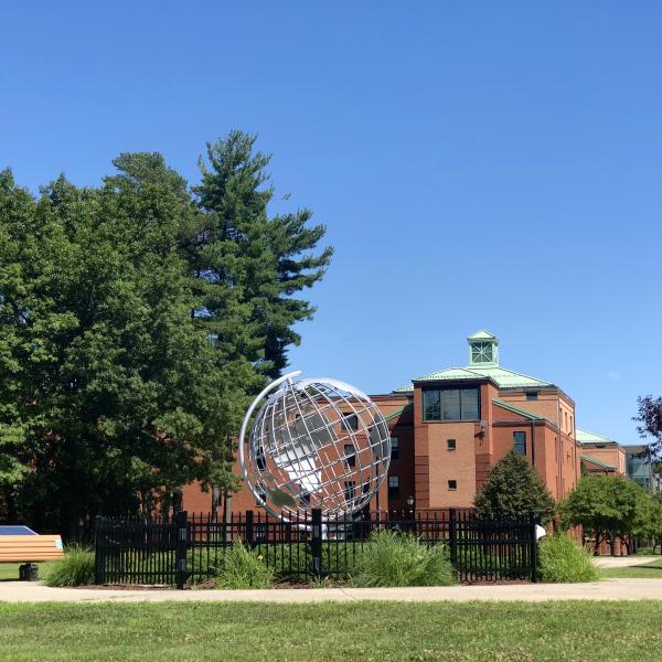 image of the globe on the campus green with Courtney Hall in the background