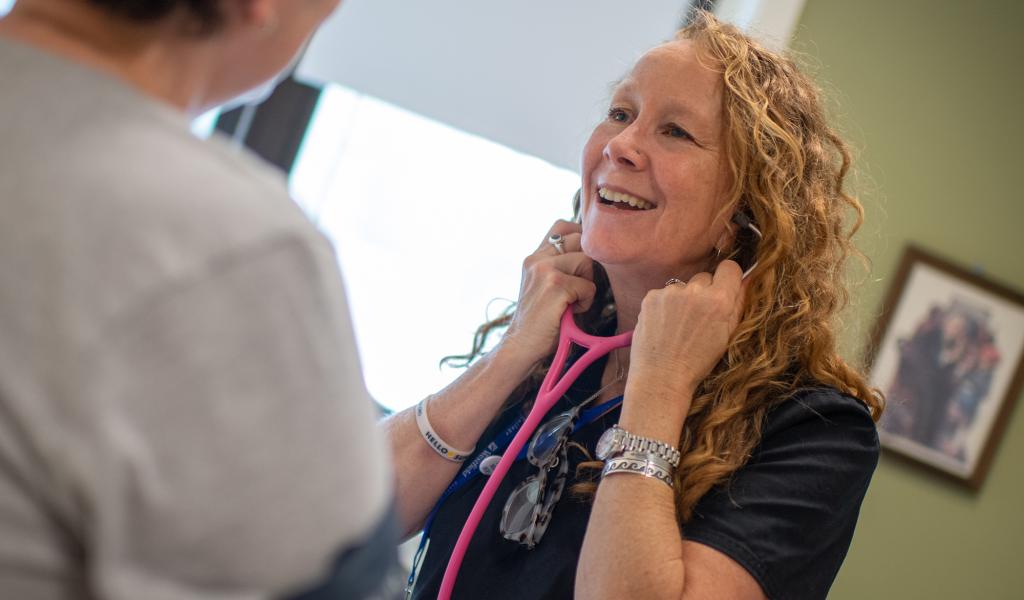 Health Services Director Kelly Palm with stethoscope and patient