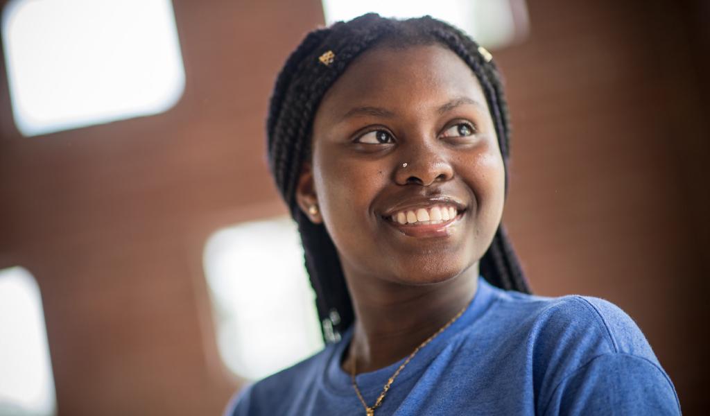 Westfield State University Promise orientation leader, and student ambassador smiling wearing blue shirt with long braids.