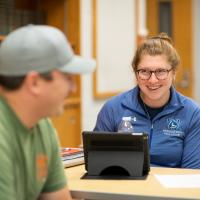 Student smiling with laptop in Public Administration course