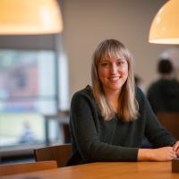 Ailish Ferrick smiling in campus library.