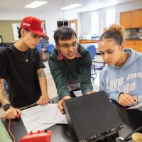 Professor Vaitheeswaran working alongside two students in classroom.