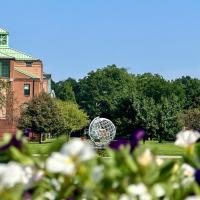 A campus stock photo of the globe. Blurred out flowers are posed in front of it.